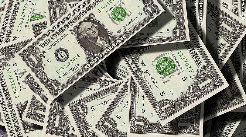 Eine große Menge 1-Dollar-Scheine liegen ungeordnet da. 