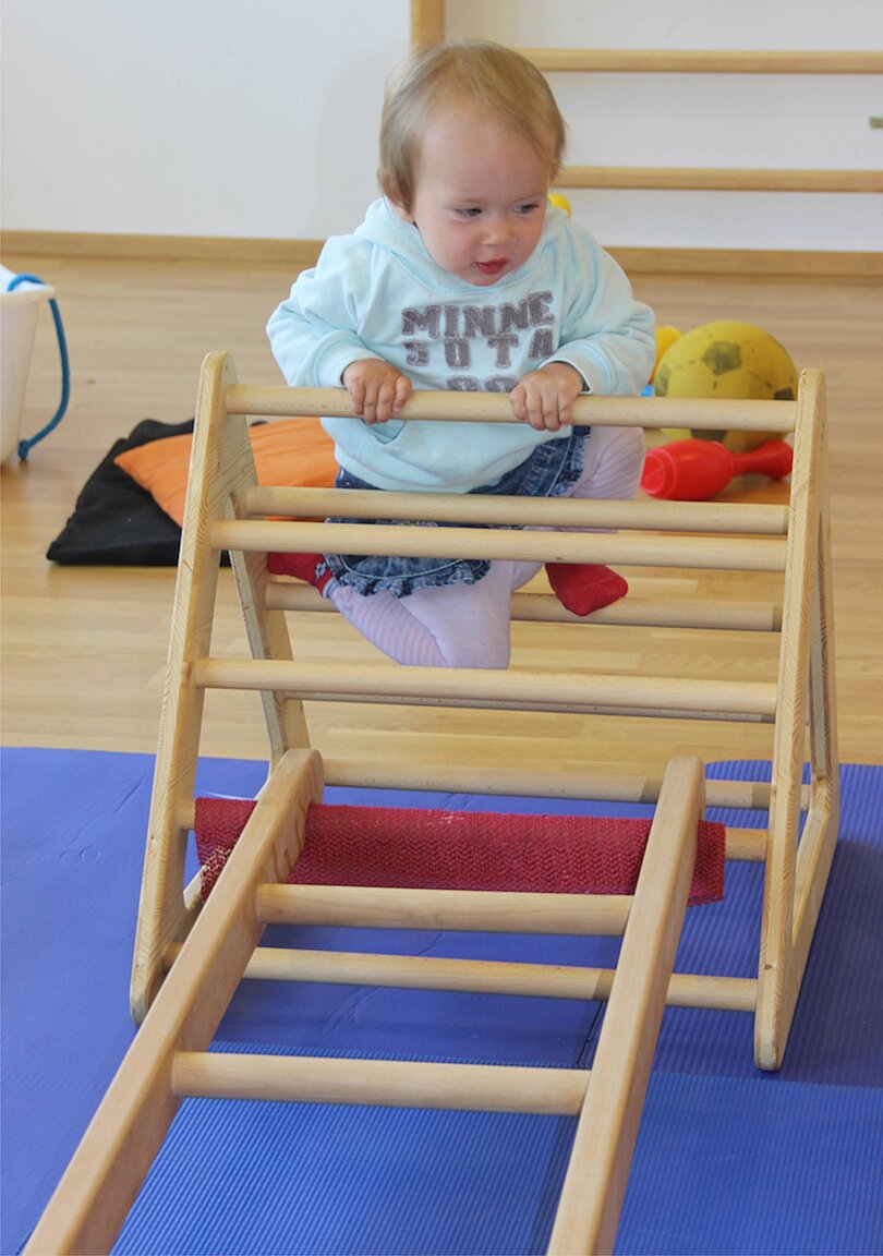 Mädchen klettert über ein Hengstenbergdreieck. 