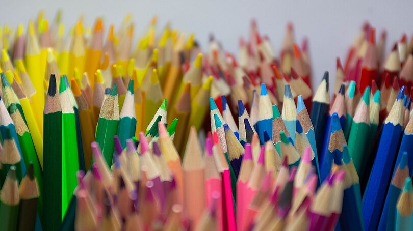Nach Farben sortierte Buntstifte sehen, stehen mit der Spitze nach oben in runden Behältern.